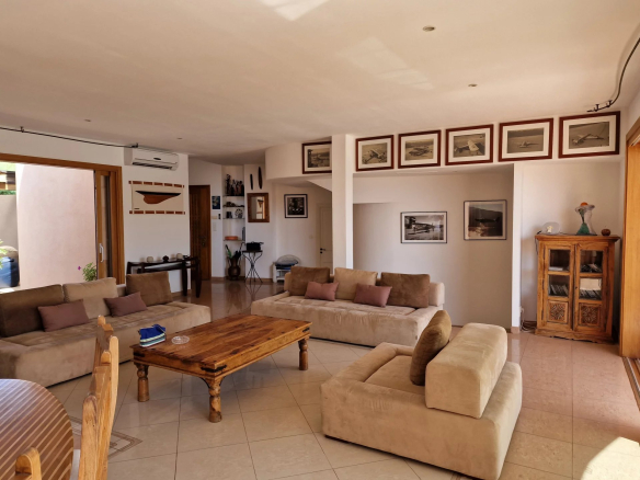 Intérieur d'une villa spacieuse avec canapés et décorations murales, Marine de Davia, Corbara.