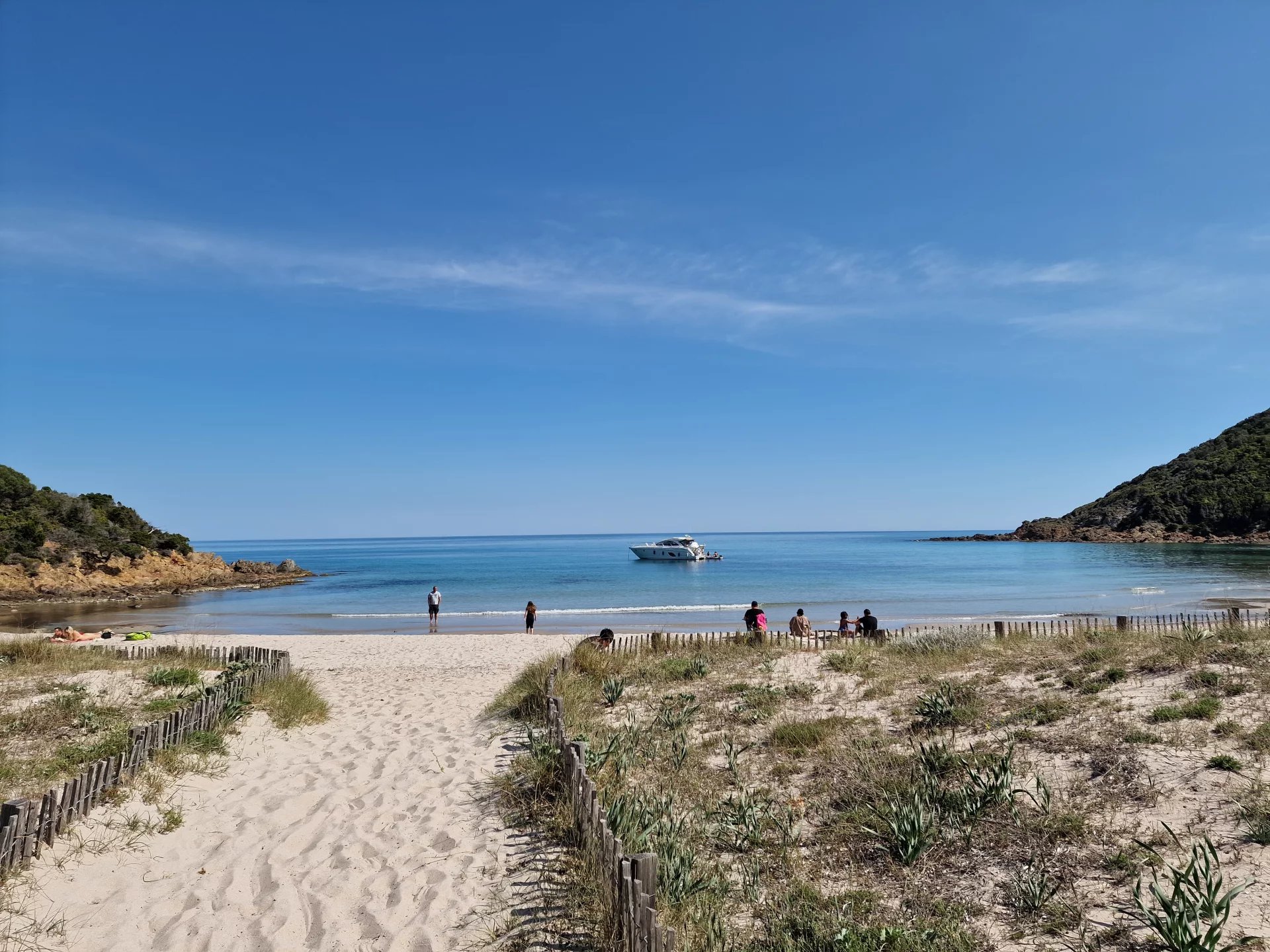 Plage de la côte Fautea Plage de sable avec des personnes se baignant et un bateau au large, côte Fautea, Conca.