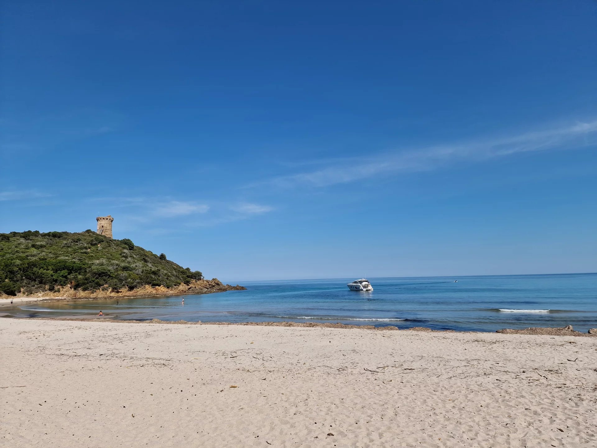 Plage de Fautea Plage de Fautea avec une tour en arrière-plan et un bateau sur l'eau.