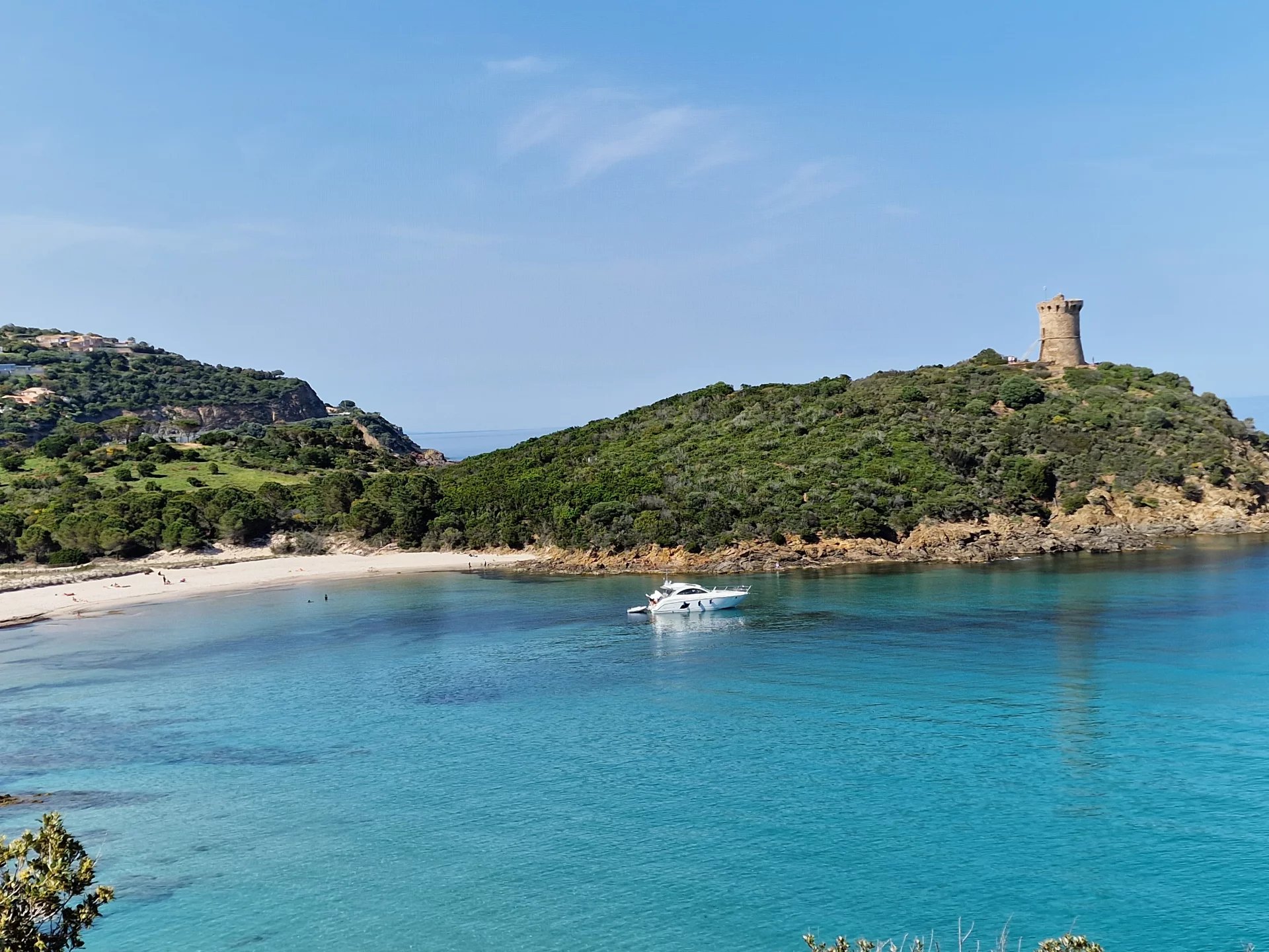 Vue côtière de Fautea Vue de la mer turquoise avec un bateau et une tour sur la côte de Fautea, près de Conca.