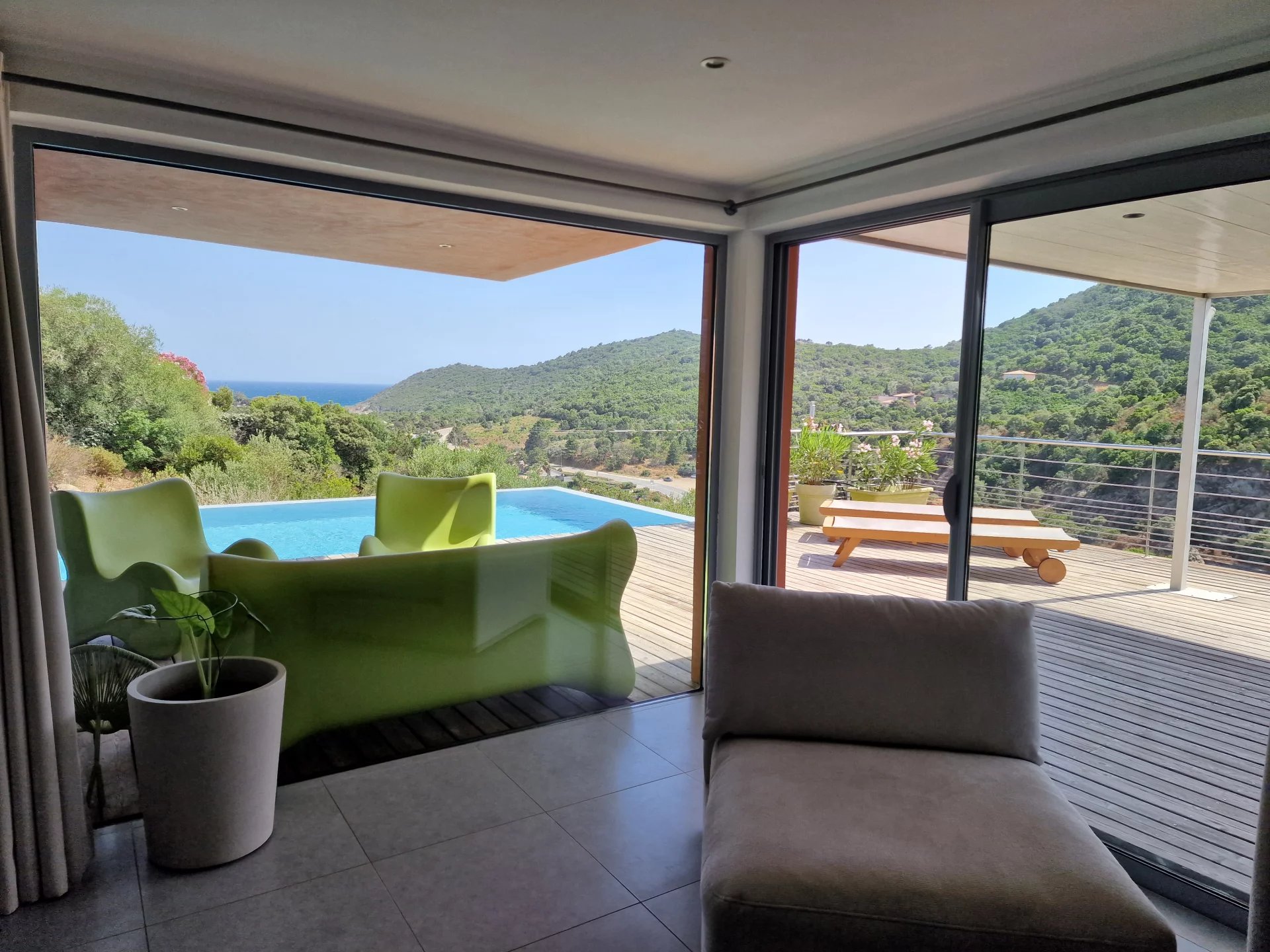 Villa d’architecte à Conca Intérieur d'une villa moderne avec vue sur la mer et les montagnes, piscine visible à l'extérieur.