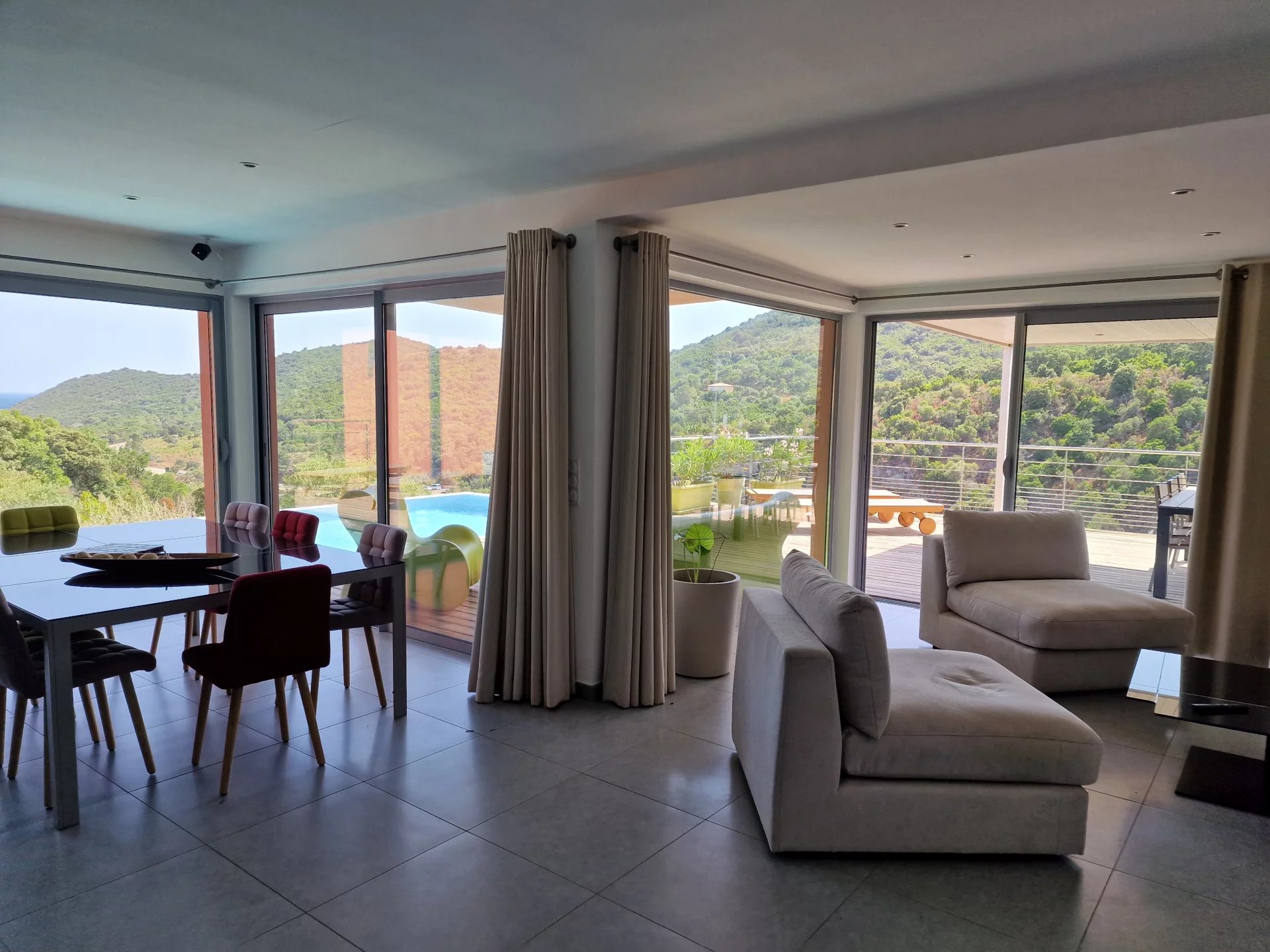 Intérieur d’une villa d’architecte Intérieur d'une villa moderne avec vue sur la nature, comprenant un salon et une salle à manger.