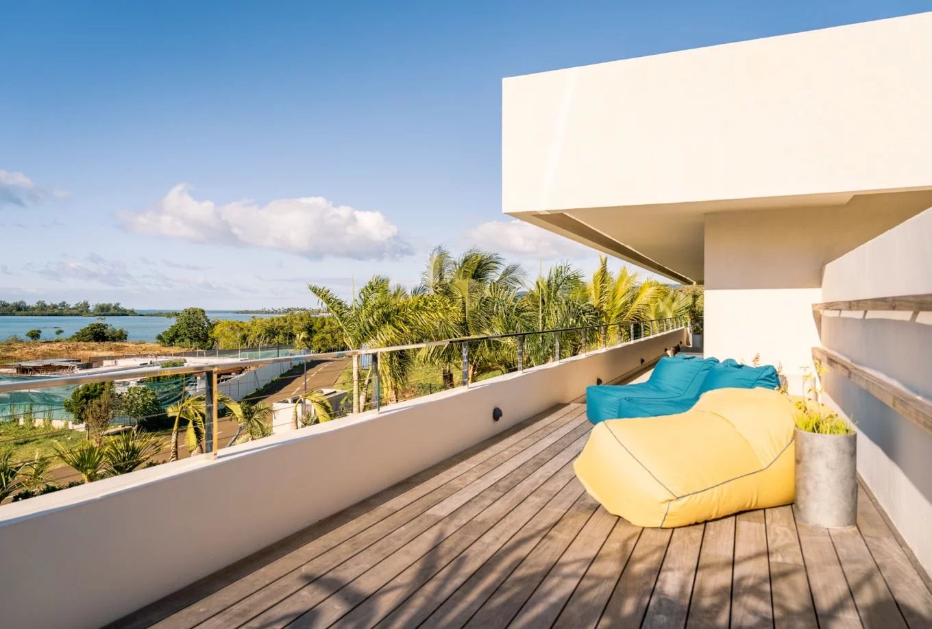 Terrasse avec vue sur le lagon Terrasse moderne avec fauteuils confortables, vue sur le lagon et la végétation environnante.
