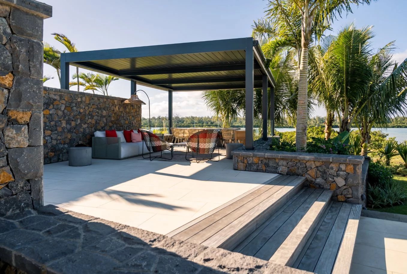 Terrasse avec vue sur le lagon Terrasse moderne avec mobilier de jardin, vue sur le lagon et les palmiers.