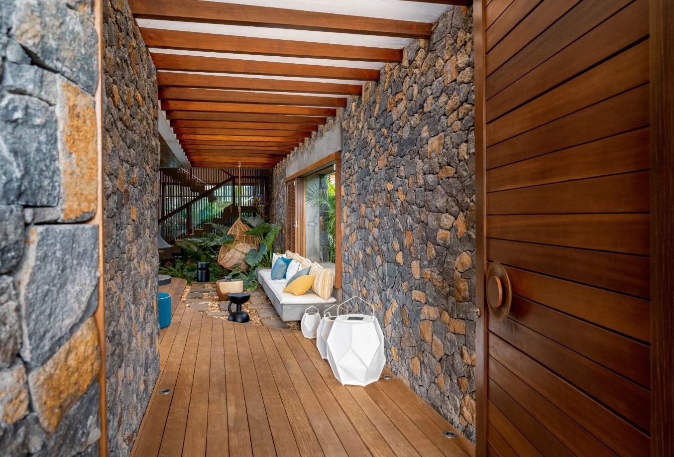 Intérieur d’une somptueuse propriété Intérieur d'une propriété moderne avec murs en pierre et un sol en bois, décor tropical.