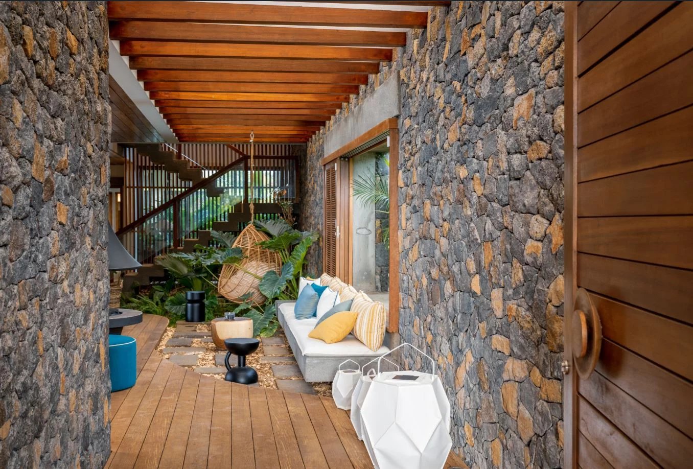 Intérieur d’une somptueuse propriété Intérieur d'une propriété moderne avec murs en pierre, mobilier élégant et décoration tropicale.
