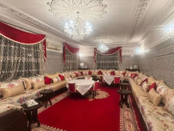 Intérieur d'une villa de luxe avec tapis rouge et décor traditionnel.