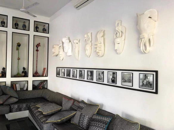 Intérieur d'une propriété avec des sculptures murales et des photos encadrées, salon confortable.