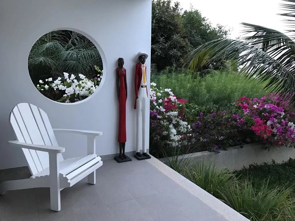 Entrée d’une somptueuse propriété à Cap Skirring Entrée d'une propriété avec des sculptures et des fleurs colorées.