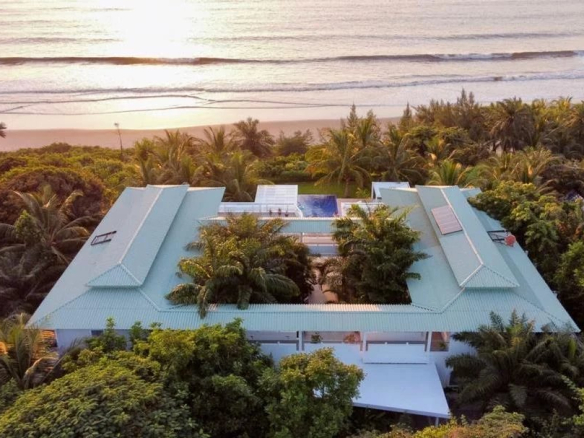Propriété en bord de mer avec piscine, entourée de végétation luxuriante à Cap Skirring, Sénégal.