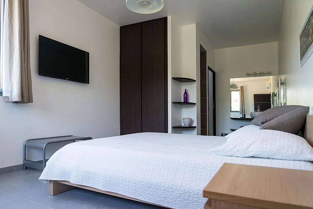 Chambre de villa moderne Chambre d'une villa moderne avec lit double et télévision murale.