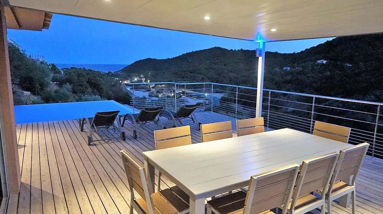 Terrasse avec vue à Conca Terrasse en bois avec vue sur la mer et la montagne, équipée d'une table et de chaises, à Conca.
