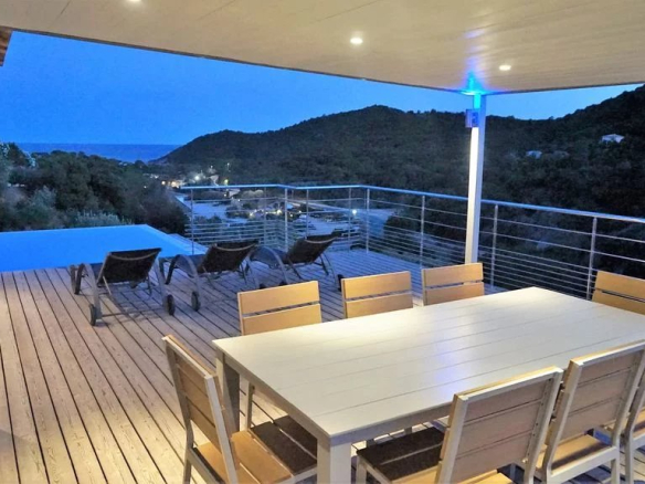 Terrasse d'une villa d'architecte avec vue sur la mer et la montagne, piscine à débordement.