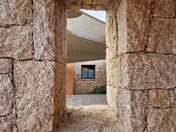 Vue à travers une ouverture en pierre d'une villa contemporaine à Porto-Vecchio.