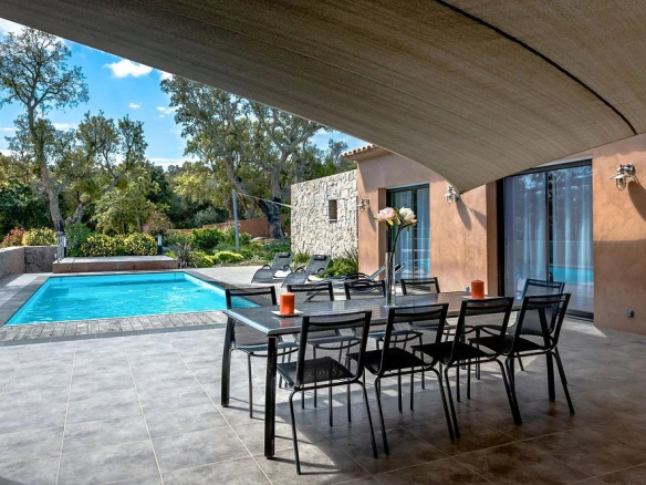 Terrasse d'une villa contemporaine avec piscine, chaises longues et table à manger, Porto-Vecchio.