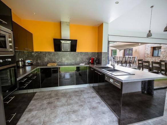 Cuisine moderne d'une villa contemporaine à Porto-Vecchio, avec comptoir et équipements modernes.