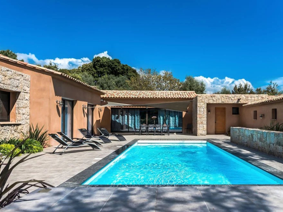 Villa contemporaine avec piscine à Porto-Vecchio, vue sur le jardin et le ciel bleu.