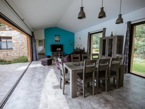 Intérieur d'une villa contemporaine avec un grand séjour et une cuisine américaine à Porto-Vecchio.