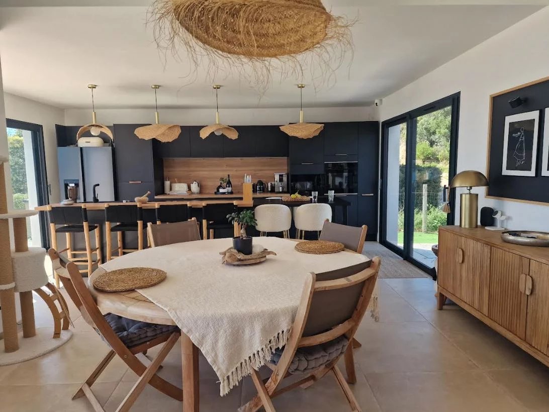 Interior of a modern villa in Sari-Solenzara Interior of a modern villa with an open-plan dining room and kitchen, overlooking the outside.