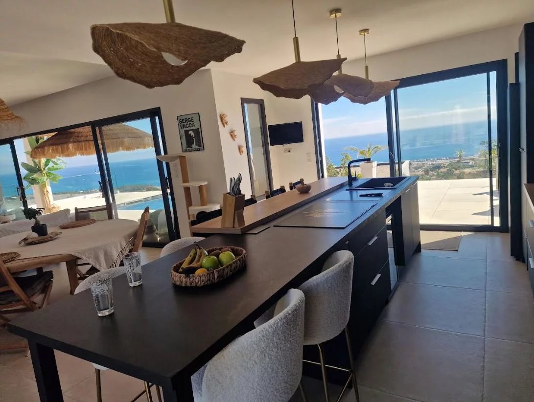Modern villa with sea view in Sari-Solenzara Modern interior of a villa with sea views in Sari-Solenzara, open kitchen and dining room.