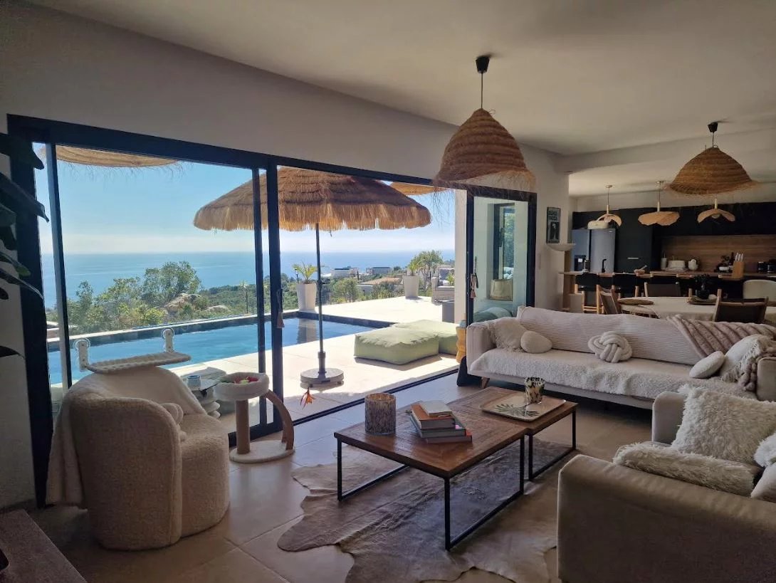Modern villa with sea view in Sari-Solenzara Interior of a modern villa with sea views, bright living room and elegant decor.