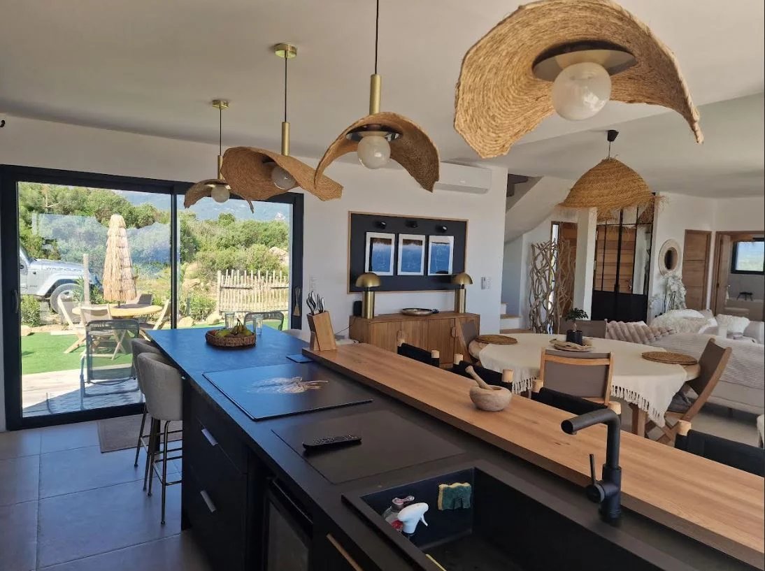 Villa interior with sea view Interior of a modern villa with open kitchen and living room, overlooking garden and sea.