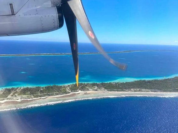 Vue aérienne de l'île de Takapoto avec un hélice d'avion en premier plan.