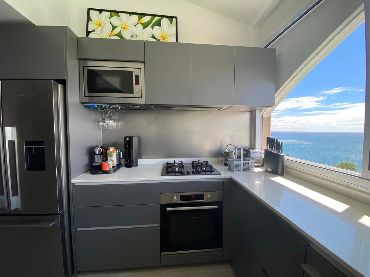 Cuisine d’un appartement style Loft à Papeete Cuisine moderne et équipée avec vue sur la mer à Papeete