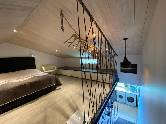 Intérieur d'un appartement style loft à Papeete avec lit et coin salon.