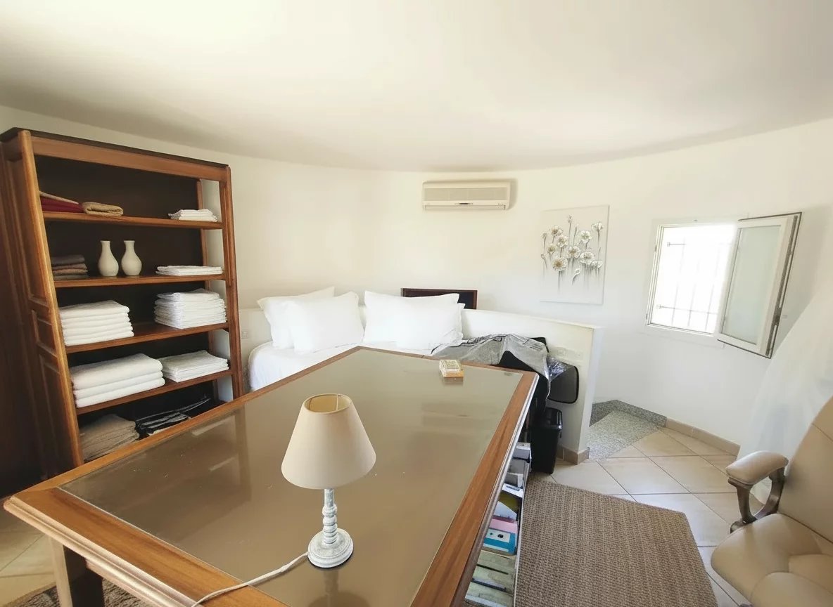 Chambre d’une demeure en pierre Chambre d'une demeure en pierre avec mobilier en bois et literie blanche.