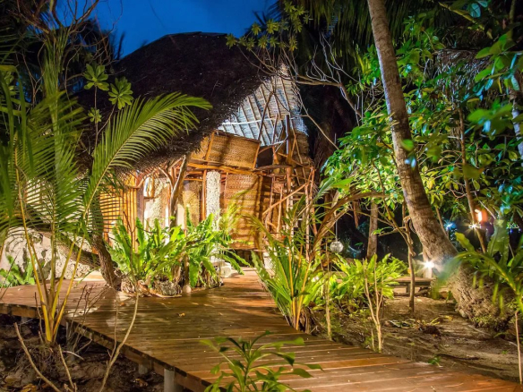 Éco-lodge de luxe en bord de mer avec bungalows artisanaux et végétation luxuriante à Tikehau.