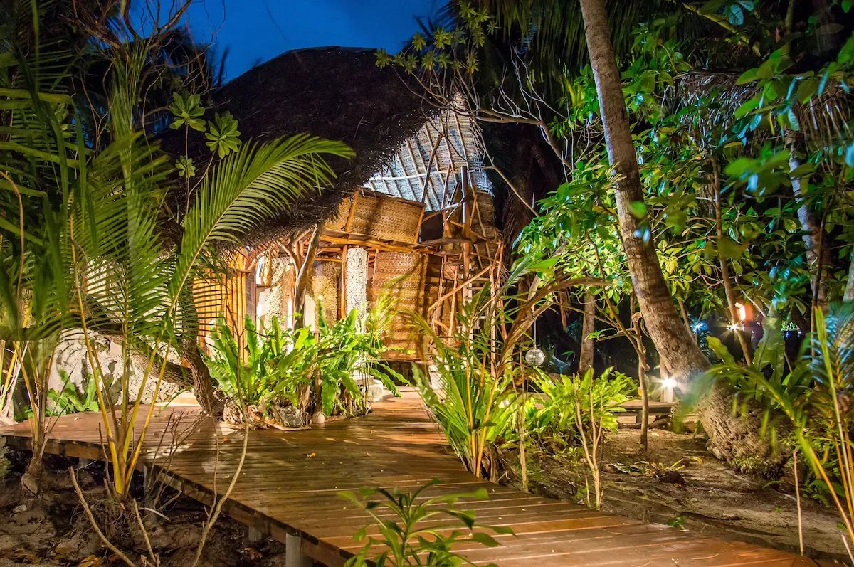 Éco-lodge de luxe à Tikehau Éco-lodge de luxe en bord de mer avec bungalows artisanaux et végétation luxuriante à Tikehau.