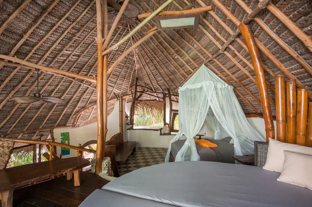 Intérieur d’un éco-lodge de luxe Intérieur d'un éco-lodge de luxe avec un toit en bambou et des lits confortables.