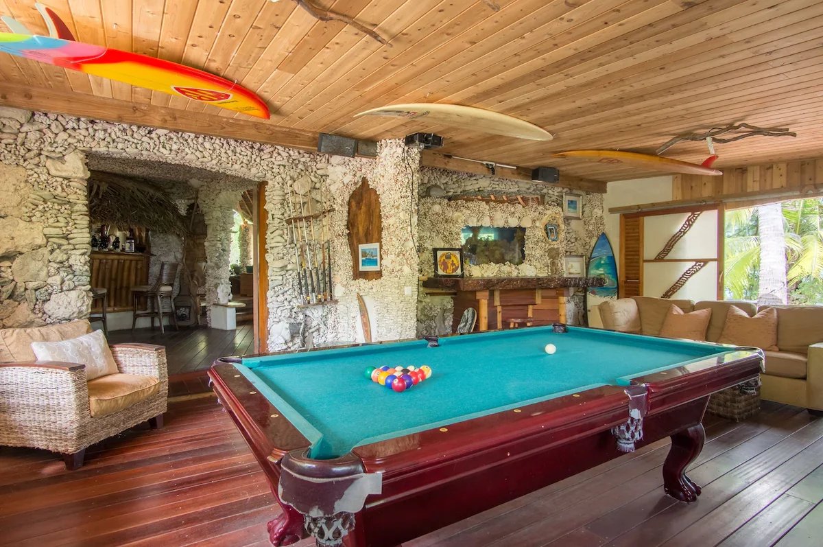 Salle de jeux de l’éco-lodge à Tikehau Salle de jeux avec table de billard et décoration en pierre dans un éco-lodge de luxe à Tikehau.