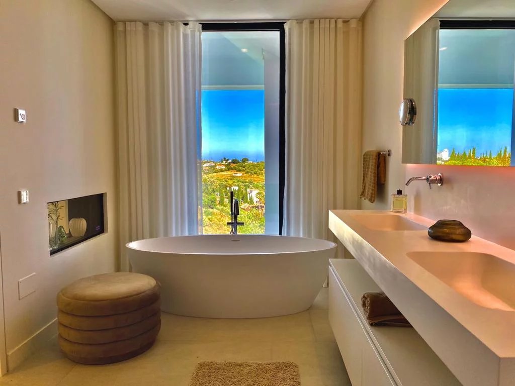 Salle de bain moderne avec baignoire et vue sur la nature à Los Flamingos, Marbella.