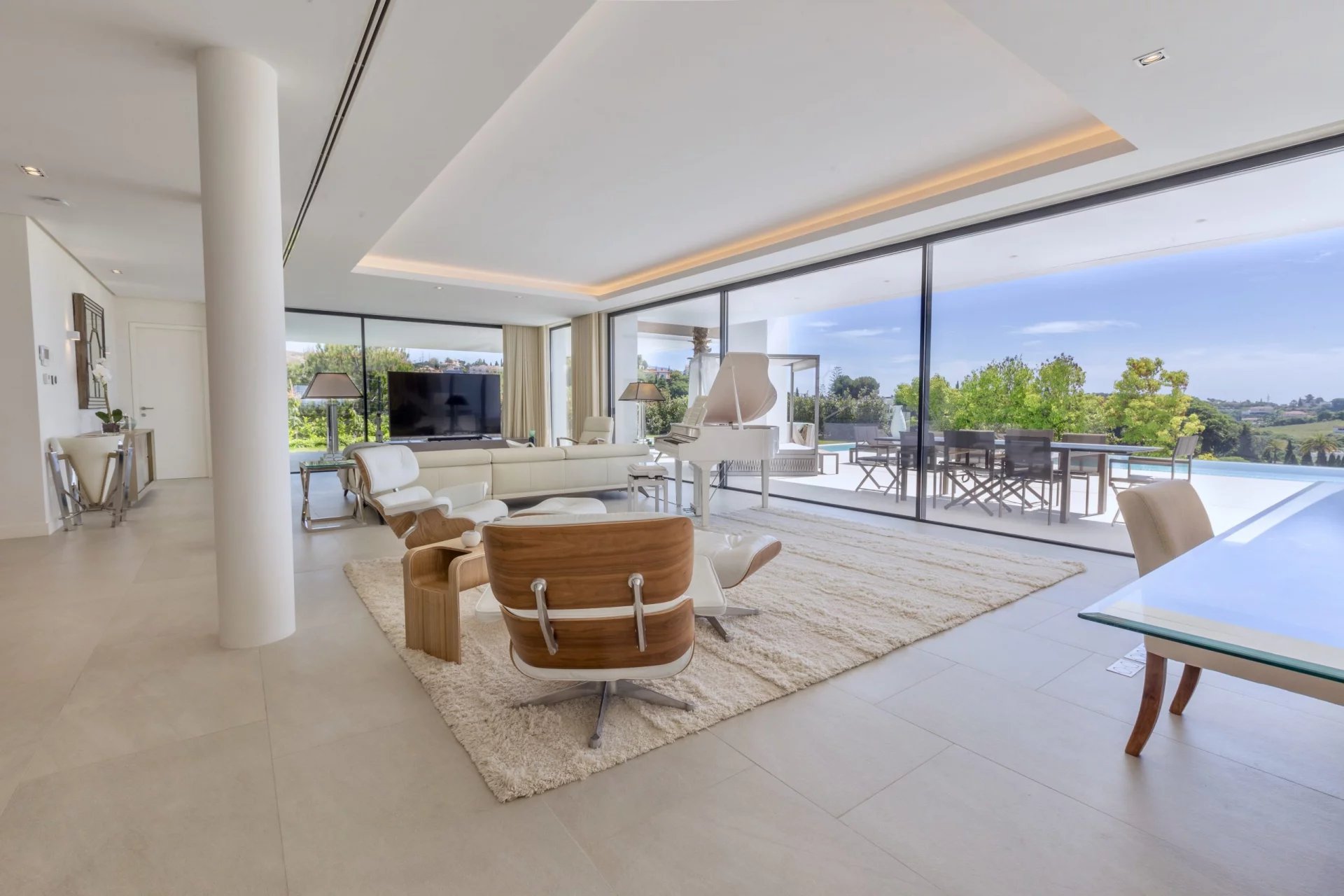 Intérieur d'une villa moderne à Los Flamingos, Marbella, avec salon lumineux et vue sur la piscine.