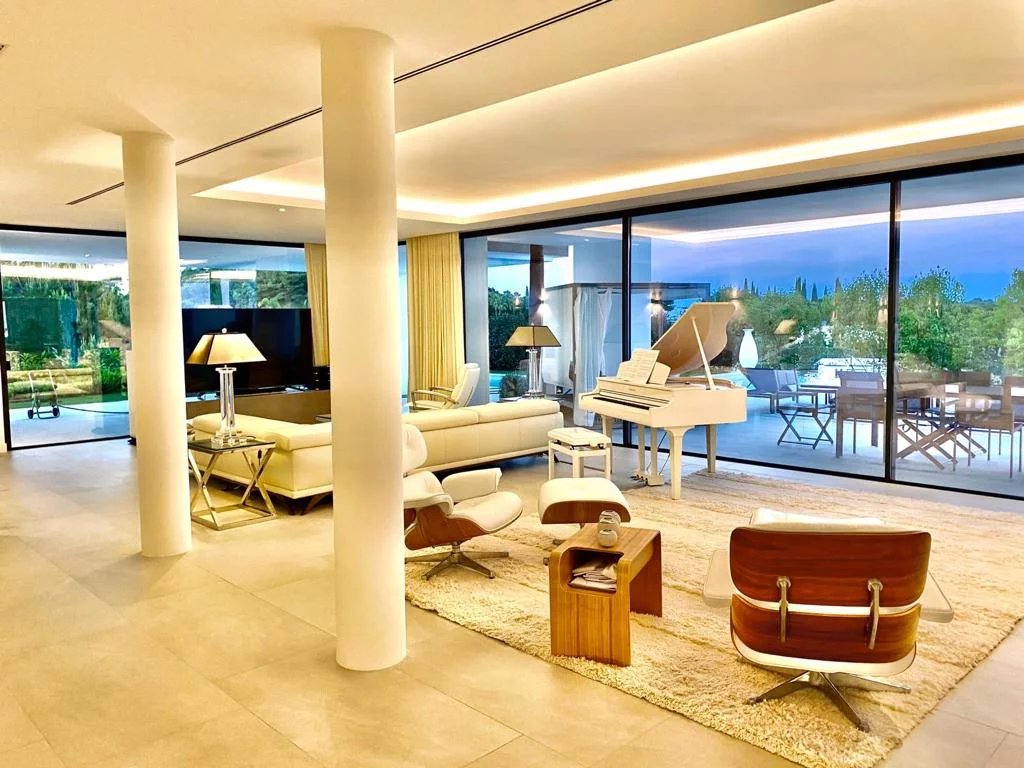 Intérieur d'une villa de luxe à Los Flamingos, Marbella, avec un salon moderne et une vue sur le jardin.