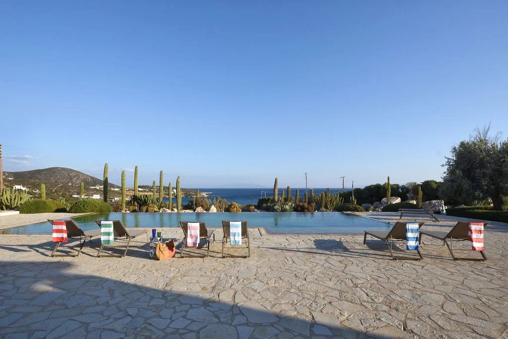 Villa d’exception à Paros Vue panoramique de la piscine et du paysage à Farangas, Paros, avec des transats en bord de mer.