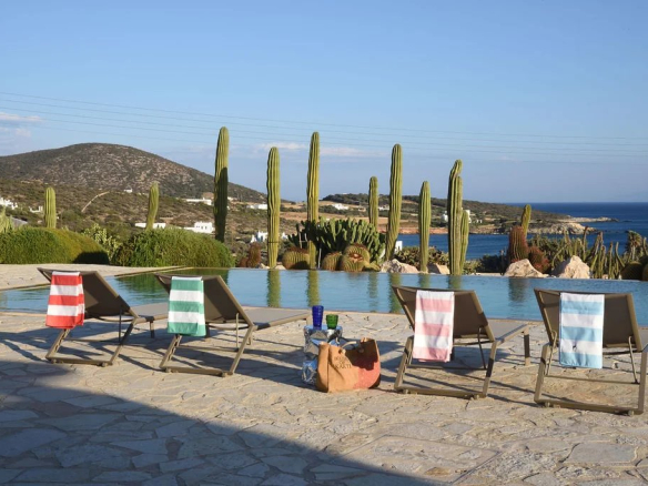 Chaises longues au bord d'une piscine avec vue sur la mer Égée à Paros, Farangas.