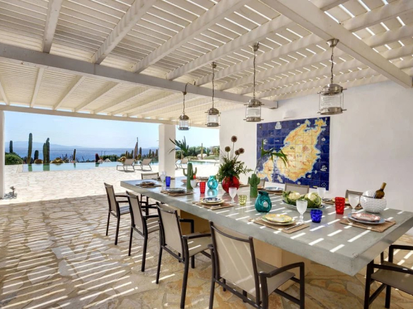 Terrasse d'une villa à Paros avec table à manger et vue sur la mer Égée.