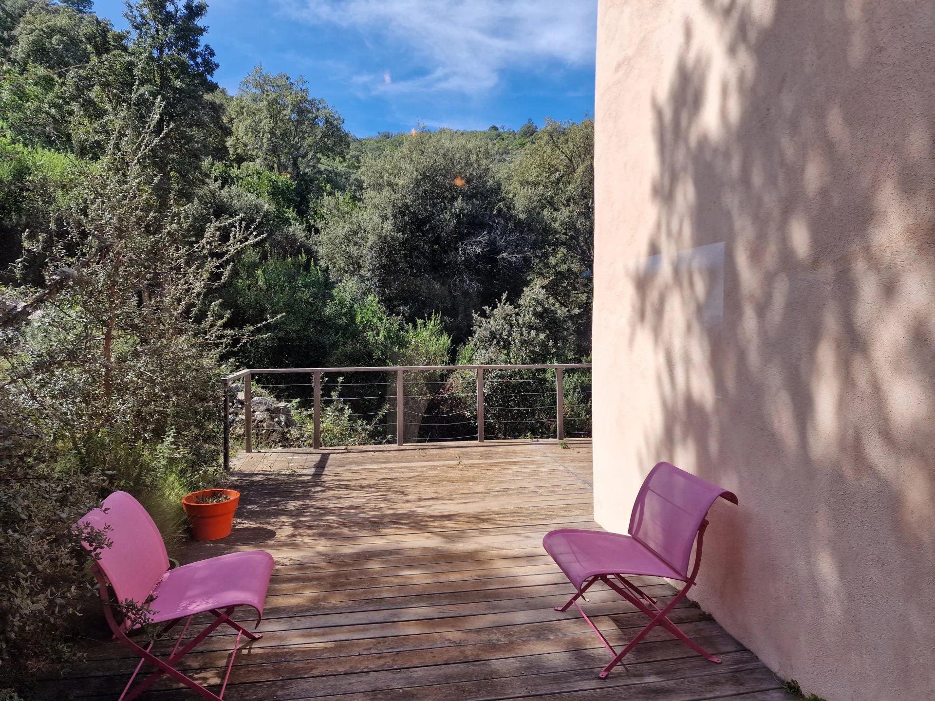 Terrace with a view in Conca Terrace with two pink chairs and a view of the surrounding vegetation in Conca.