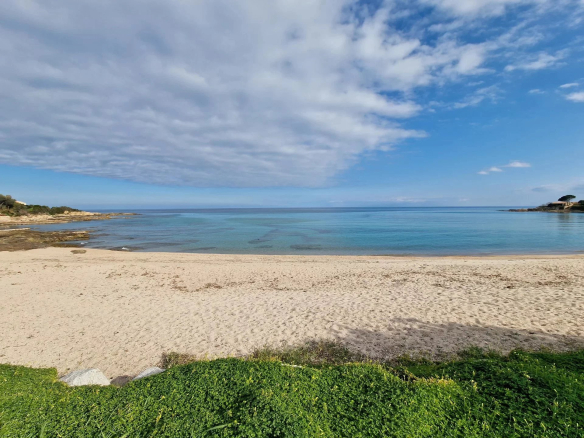 Fine sandy beach with turquoise water and cloudy skies in Conca.