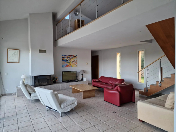 Interior of a spacious property with a large living room, fireplace and modern furniture.