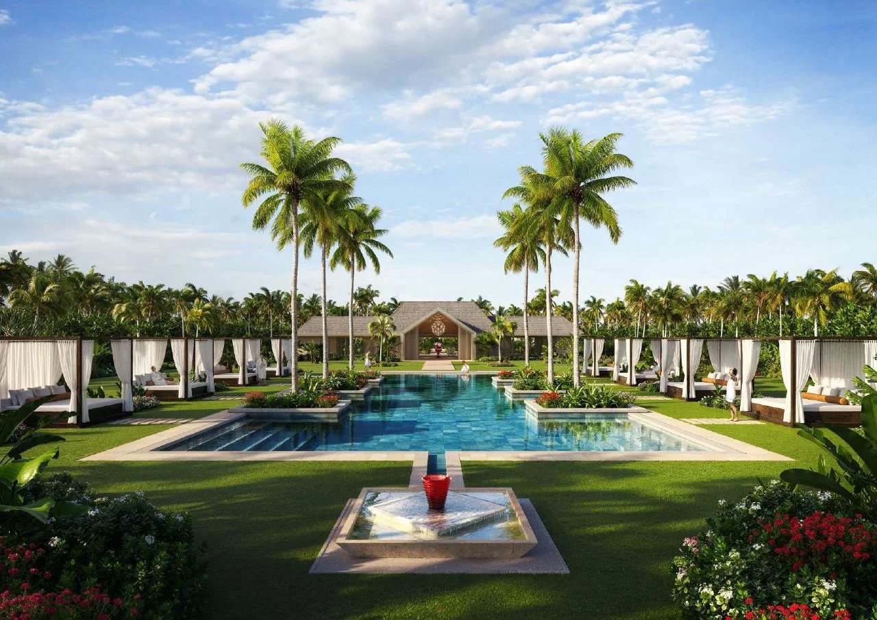 Vue d'une piscine entourée de palmiers et de cabanas dans un complexe de villas de luxe aux Maldives.