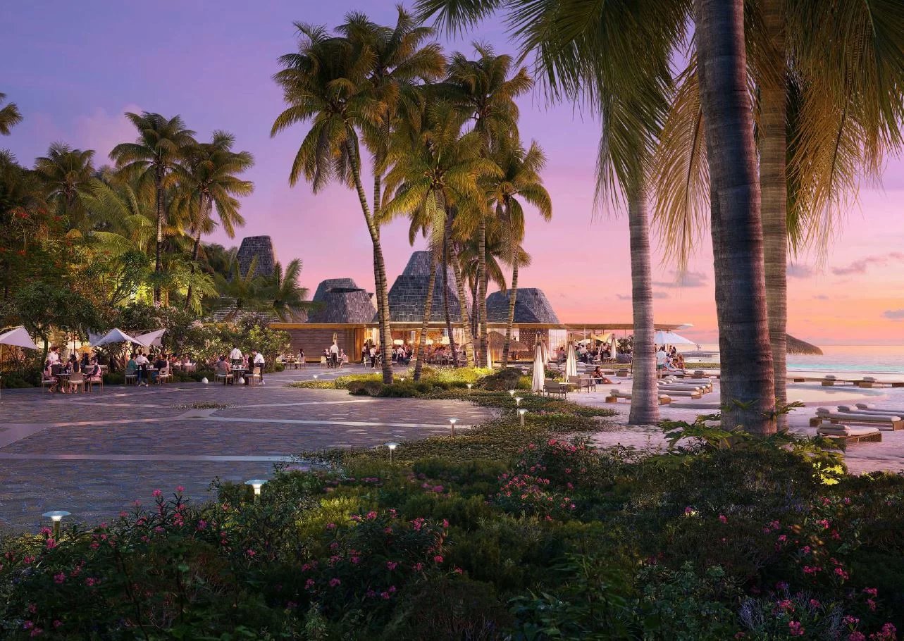 Vue d'un complexe de villas de luxe aux Maldives avec palmiers et coucher de soleil.