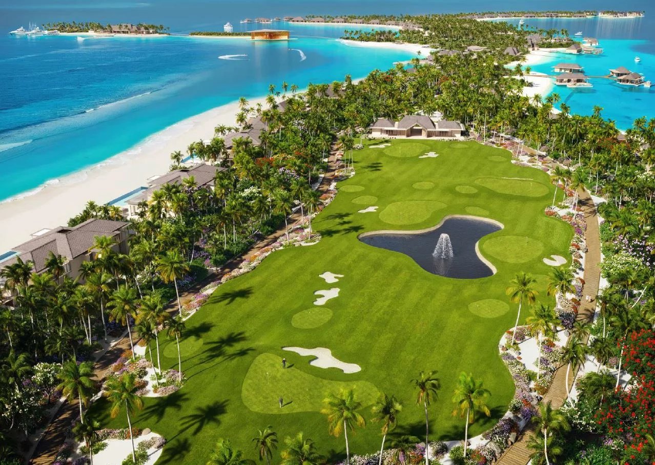 Vue aérienne d'un terrain de golf entouré de palmiers et d'eau turquoise aux Maldives.