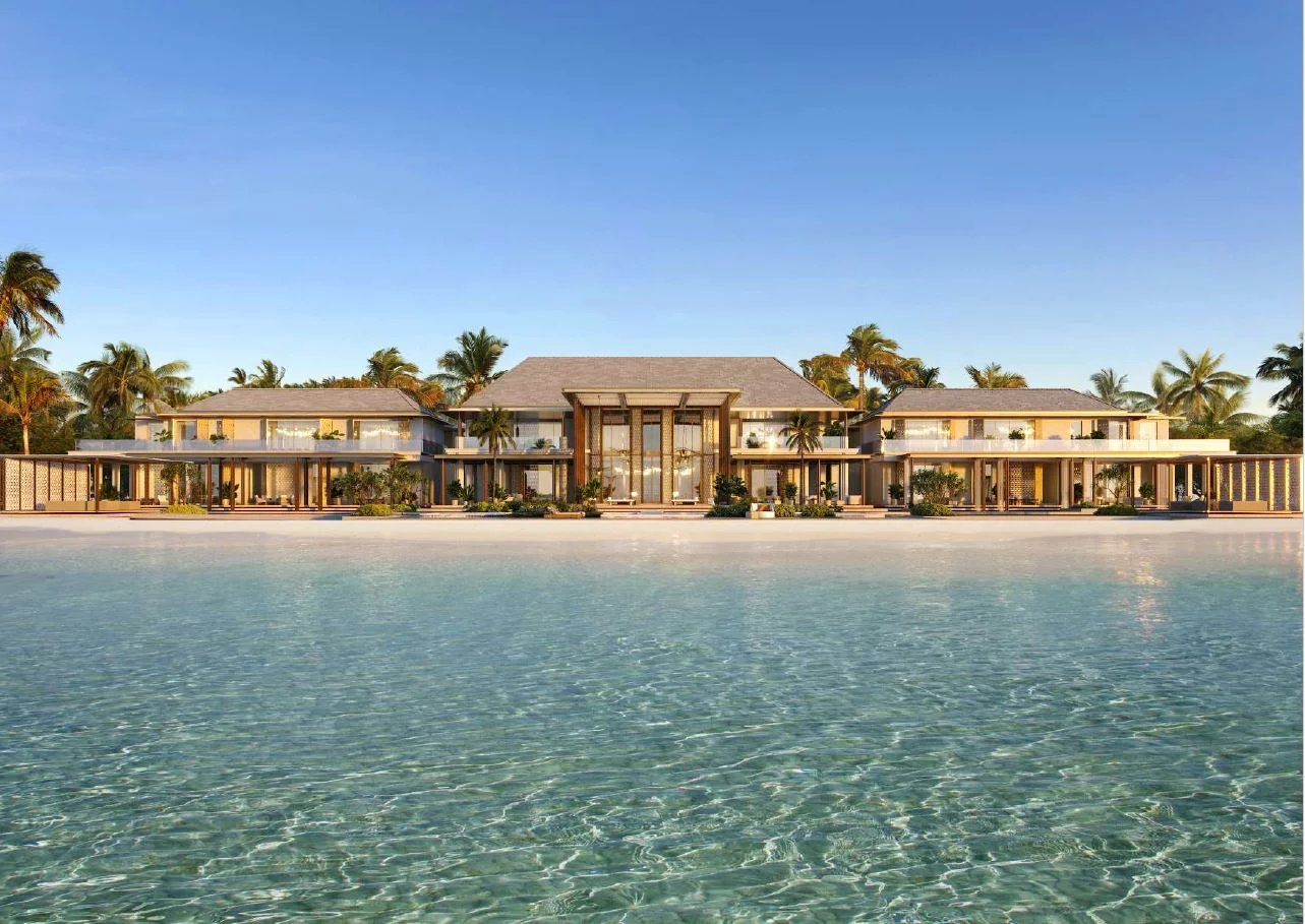 Villas de luxe sur une plage des Maldives avec palmiers et eau claire.