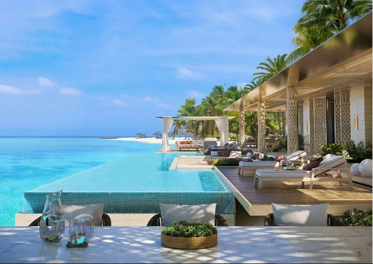 Vue d'une villa de luxe avec piscine à débordement surplombant l'océan aux Maldives.
