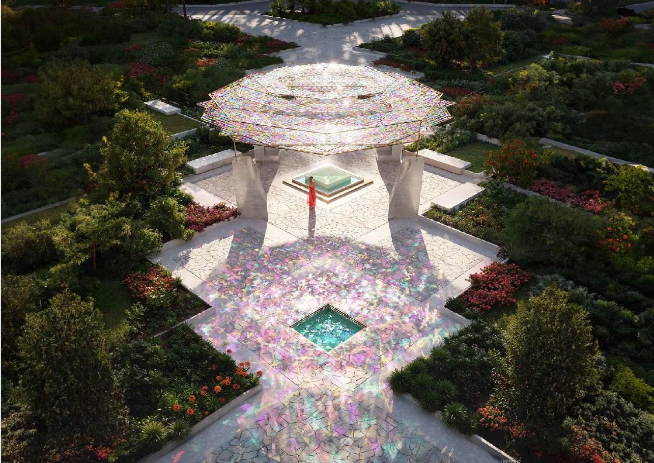 Vue aérienne d'un espace extérieur avec une structure moderne et des jardins fleuris.