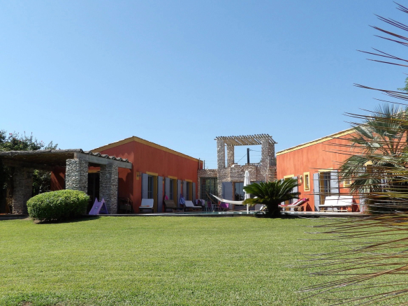Propriété avec jardin et patio à Bonifacio, vue sur la façade orange et l'espace extérieur.